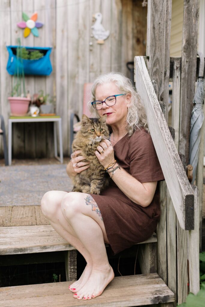 Erika Hall sitting on wooden steps holding her cat
