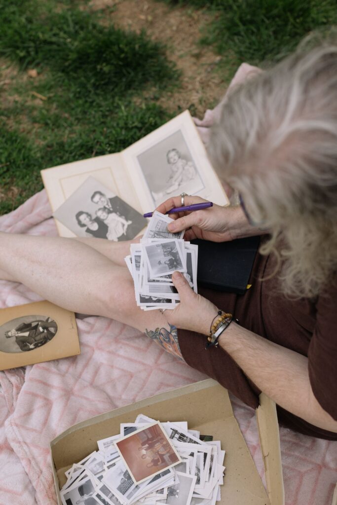 Hands sorting through old family photographs and an open photo album